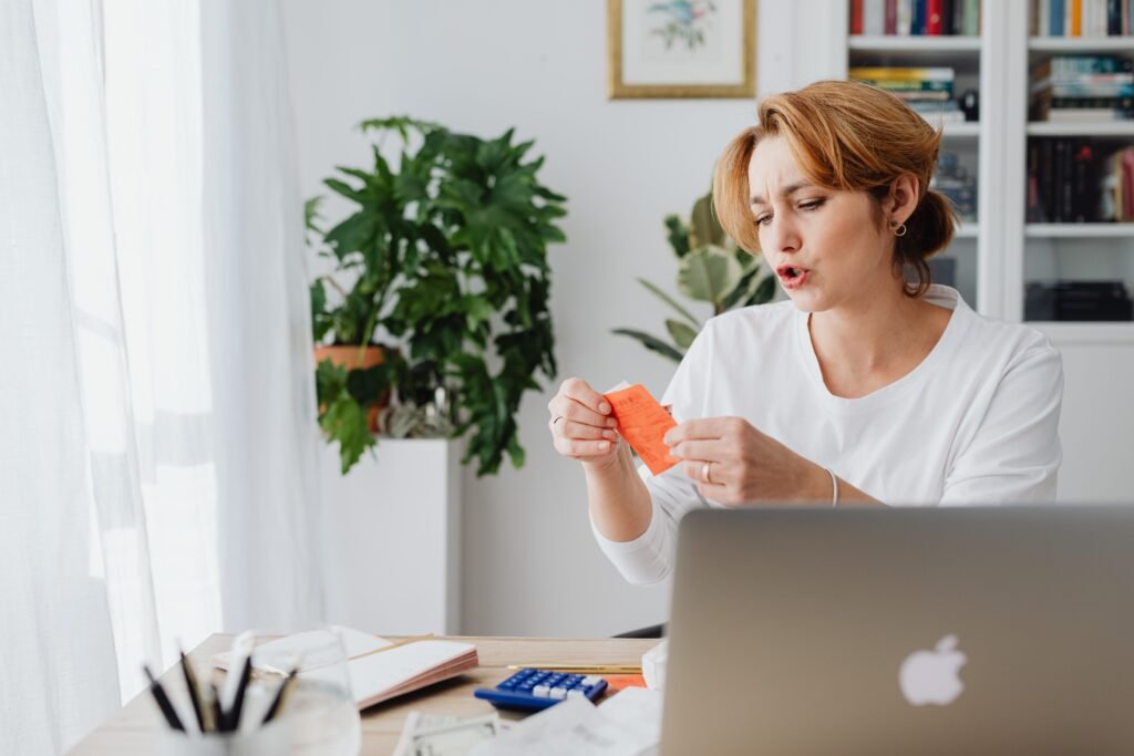 Single mum checking a receipt while reviewing her spending on a laptop